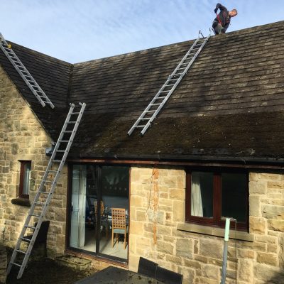 Man removes moss from Roof 