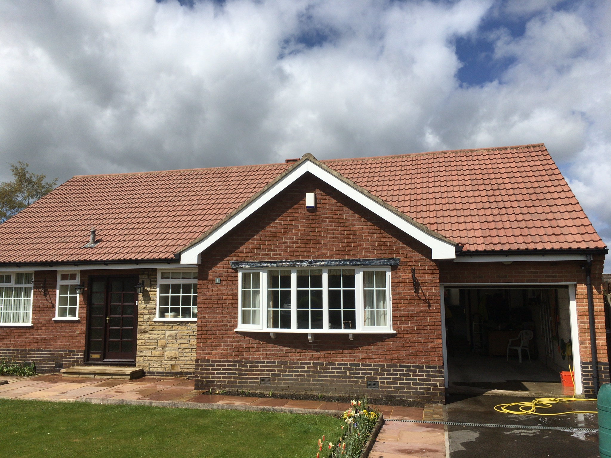 Clean red concrete-tiled roof on an Ilkley bungalow following professional moss removal and treatment.