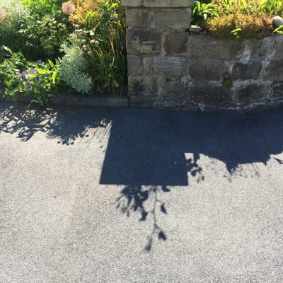 The same tarmac driveway after cleaning, with the discolouration removed and an even finish restored in Otley.