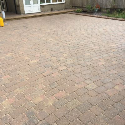Clean, re-sanded block-paved driveway with a pump sprayer ready for the sealer application.