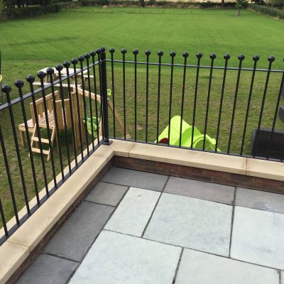 Weathered black limestone edging appearing dull grey around the pale central paving before cleaning.