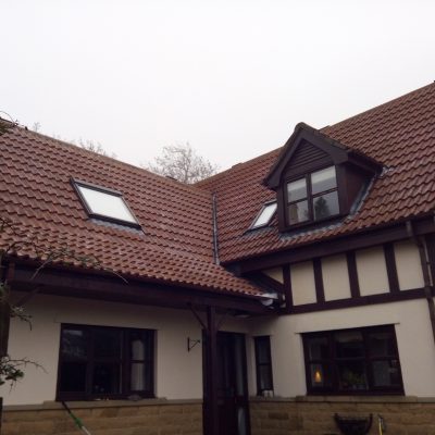 multi-pitched roof after cleaning, with the red concrete tiles, dormer and rooflights clearly visible.