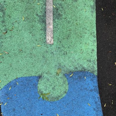 Algae-stained wet-pour rubber playground surfacing before cleaning at a school in Leeds, West Yorkshire.