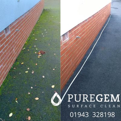 A tarmac driveway beside a brick house before and after cleaning, with green algae and moss removed to reveal its dark, even surface.