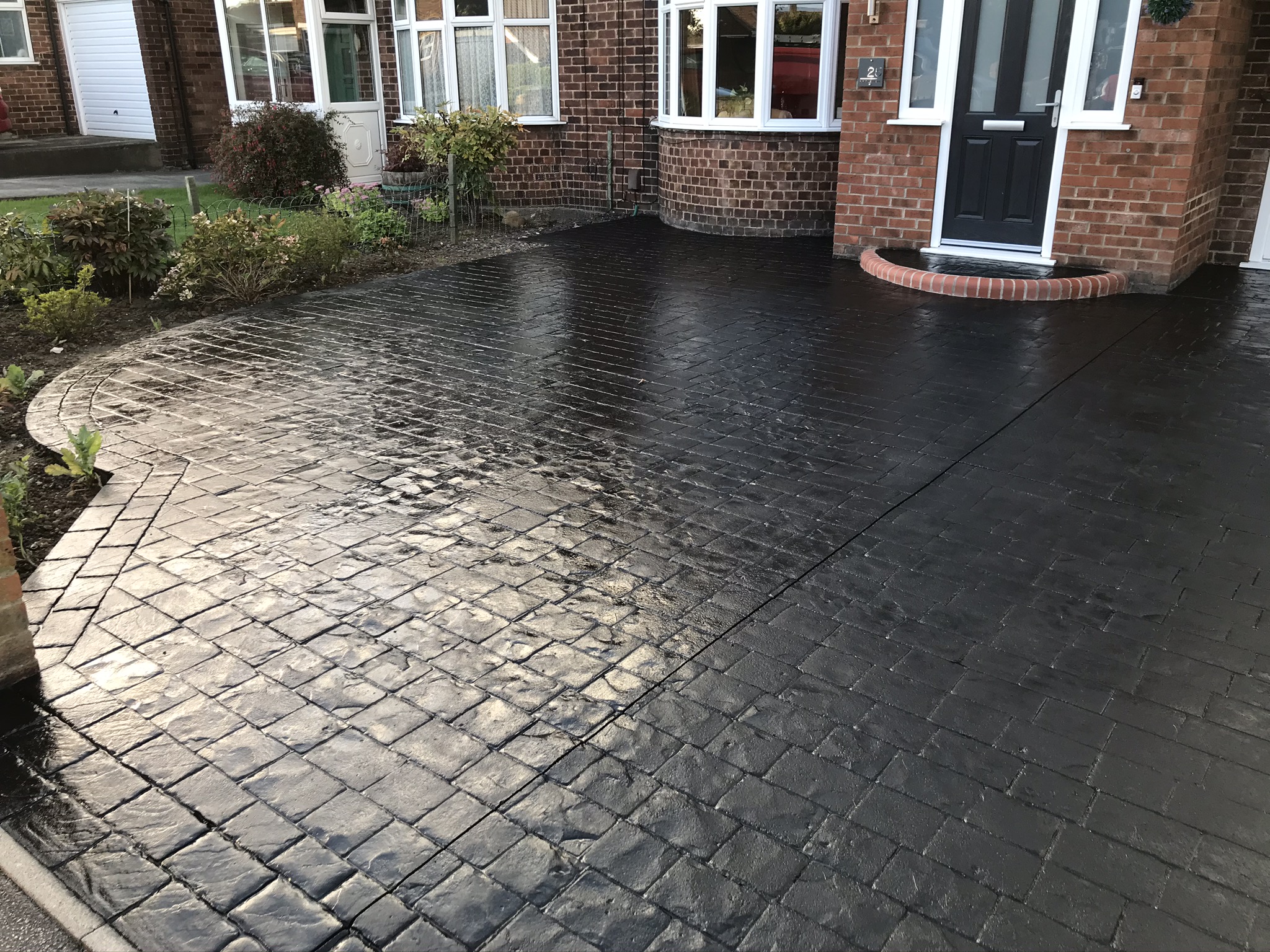 Pattern-imprinted concrete driveway after colour restoration and protective sealing at a West Yorkshire home.