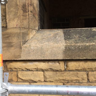 Test-cleaned sandstone window sill showing the removal of dark atmospheric staining in Leeds, West Yorkshire.